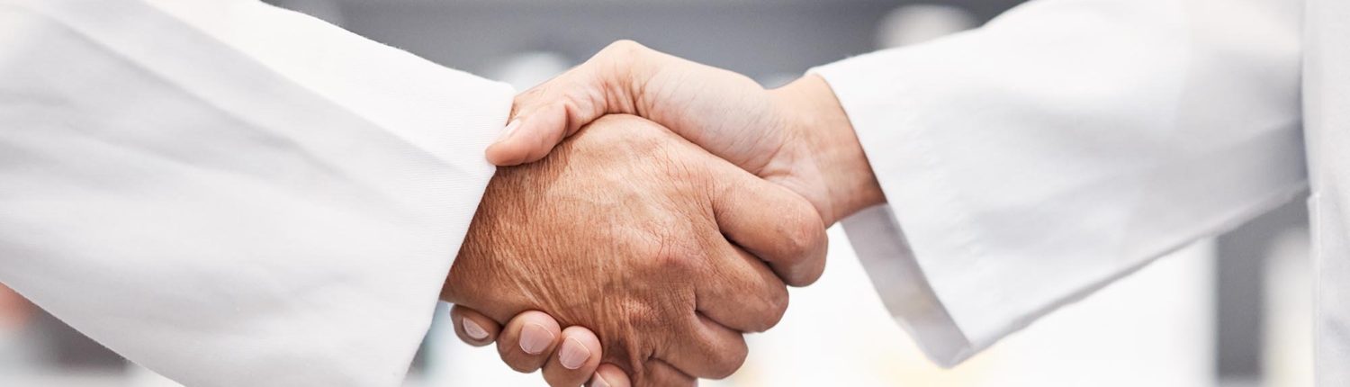 Close up of two healthcare professionals shaking hands
